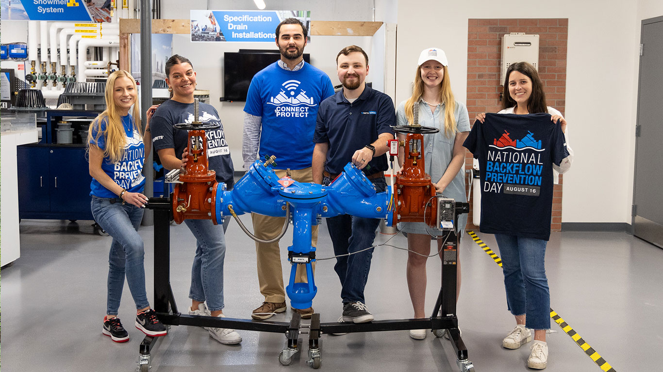 Watts employees in front of a backflow preventer on backflow day 2023.