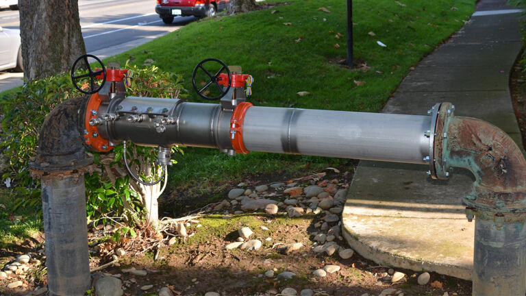 Deringer backflow valve installed on sidewalk.